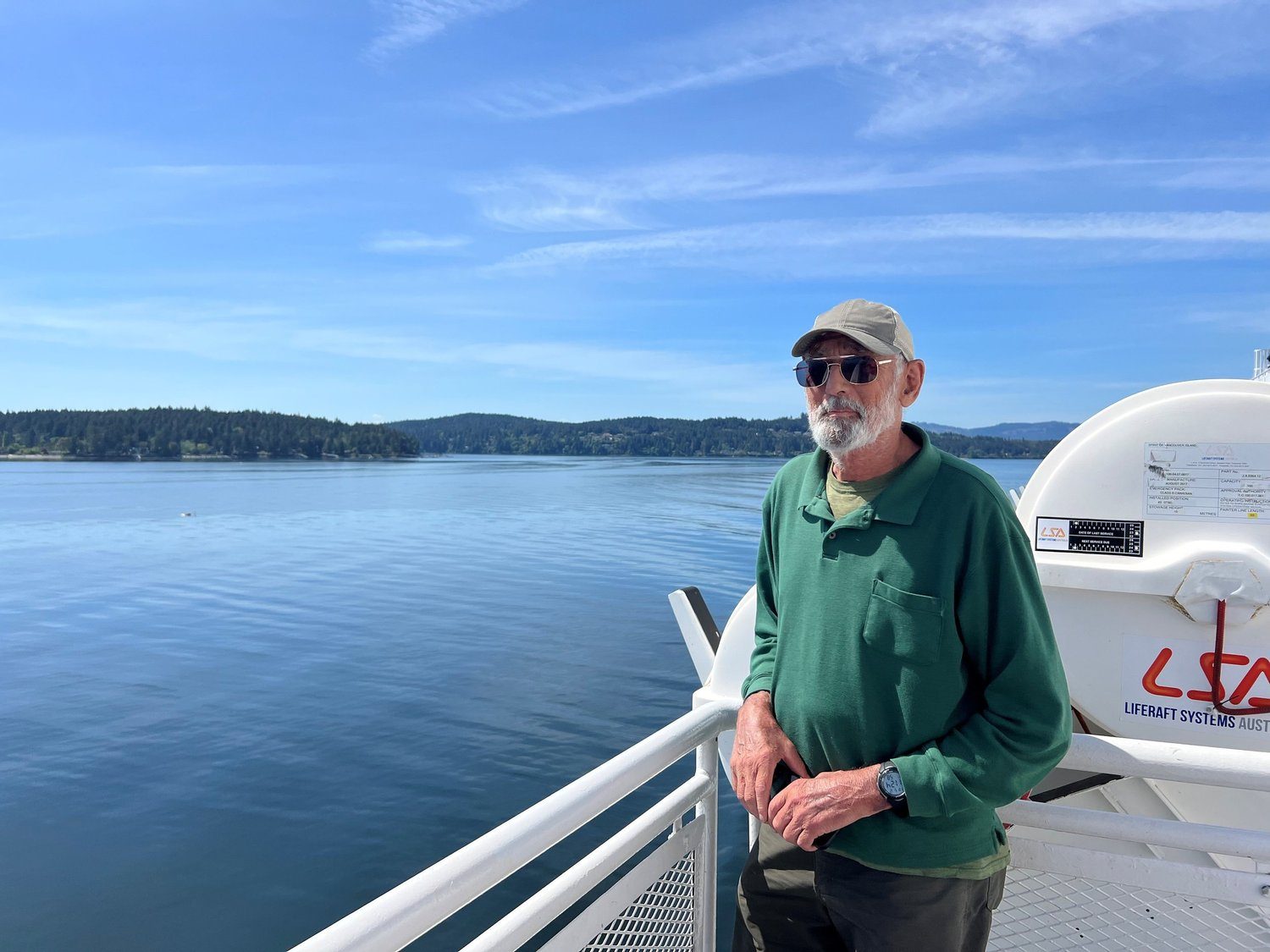 An older friend smiling on a ferry deck over blue water
