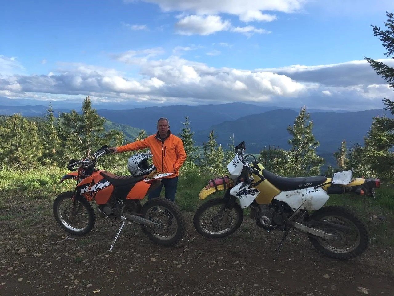 Two dirt bikes parked on a mountain overlook