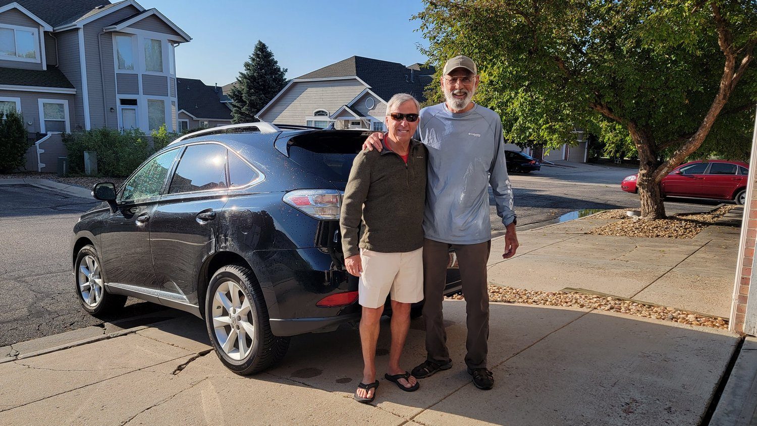 Kevin and an older friend by a car before an outing