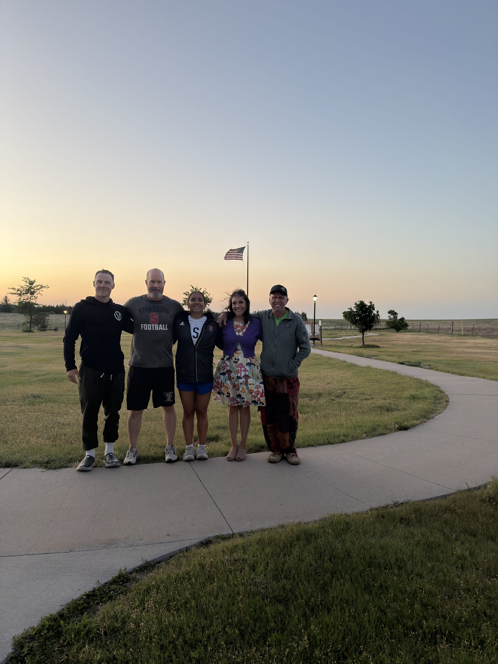 The crew and friends at sunrise beside an American flag