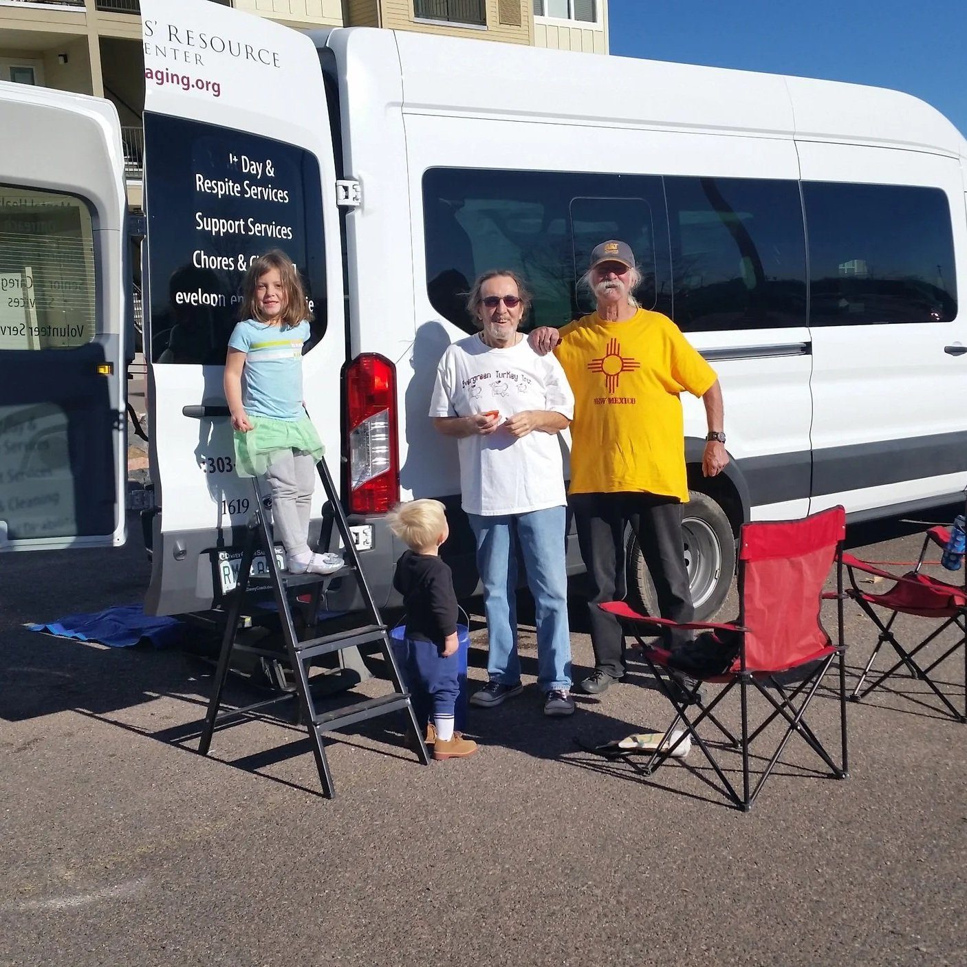 Seniors and family gathered beside a Seniors' Resource Center van